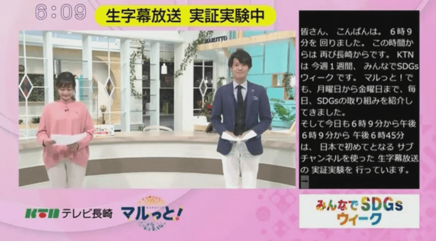 Two presenters in a live TV program with subtitles provided real time on the right side using a combination of AI and human input.