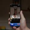 A person holding up their phone to use Gemini Live on plumbing under their sink